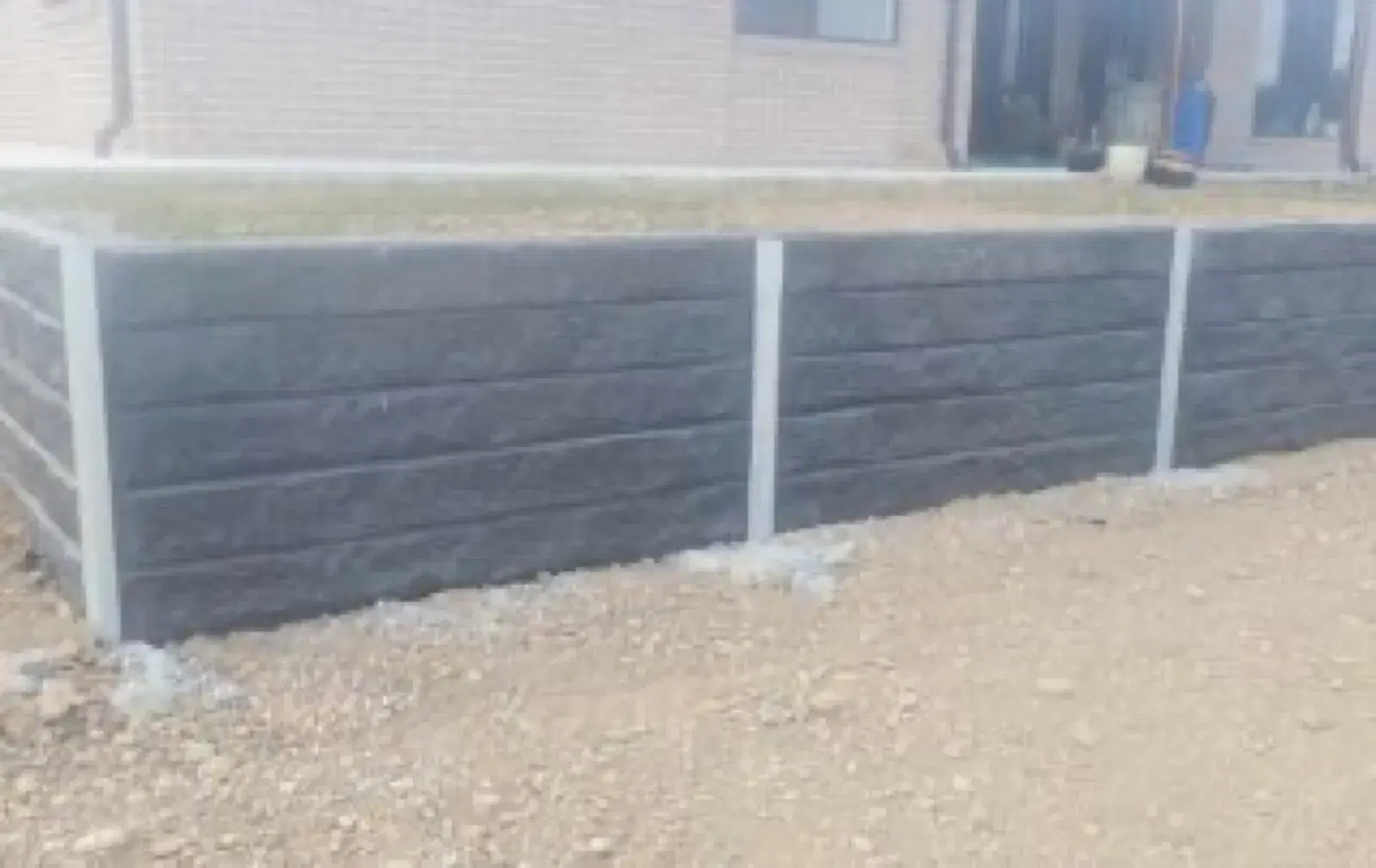 Charcoal concrete sleeper retaining wall completed for a residential property