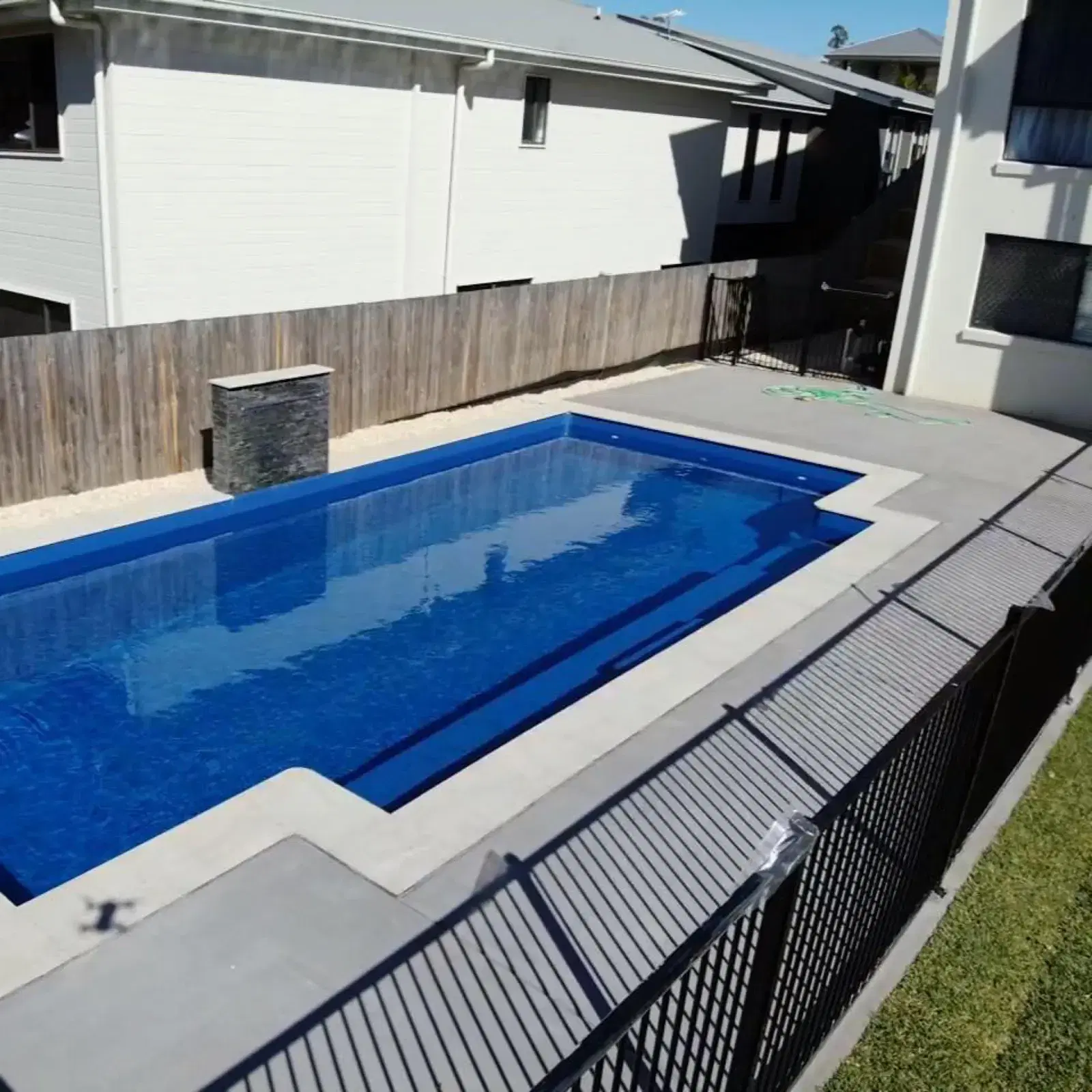 Concrete pool surround with clean edges and drainage around a Brisbane pool
