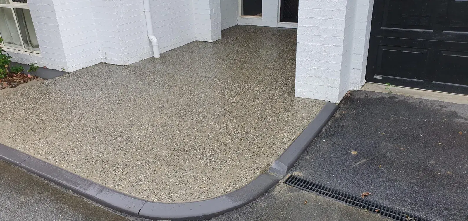 Exposed aggregate concrete entry path and outdoor area with curved edging