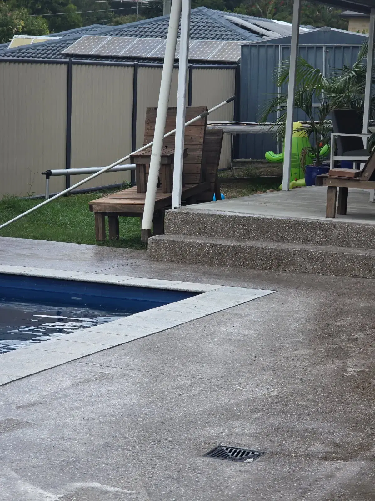 Exposed aggregate pool surround with steps, patio connection and drainage grate