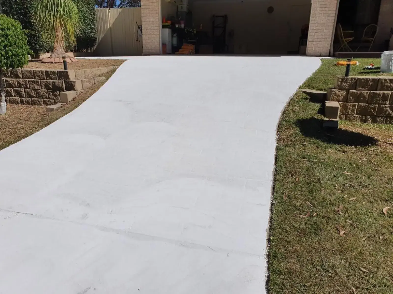 Fresh plain concrete residential driveway leading to a garage