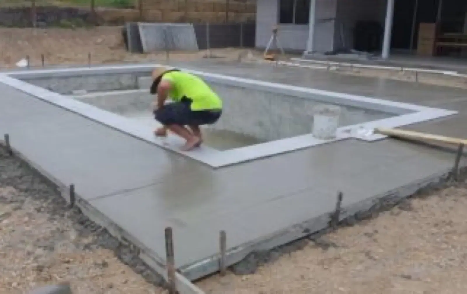 Concrete pool surround being finished during residential pool construction