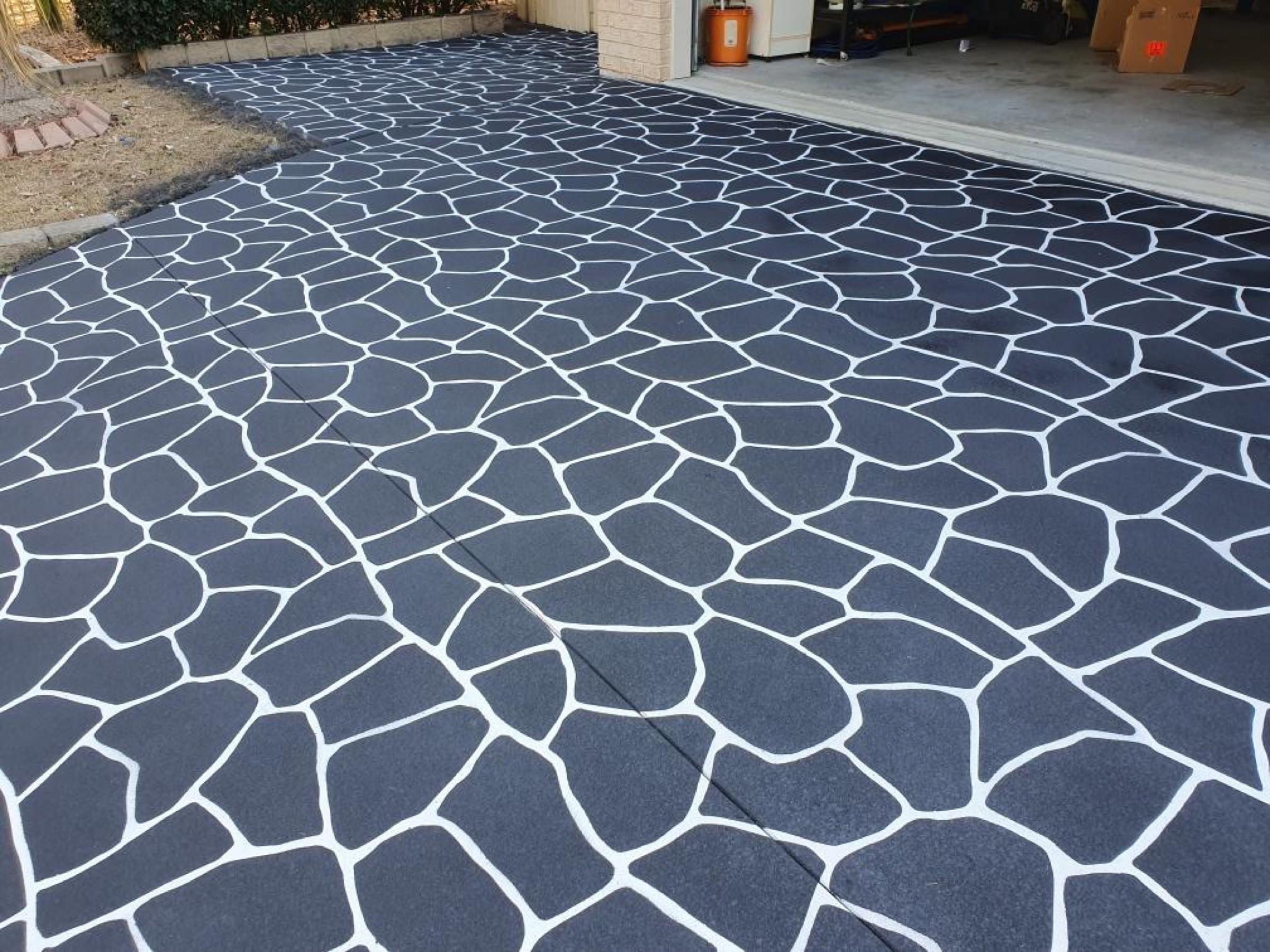 Dark decorative concrete driveway with a stone pattern