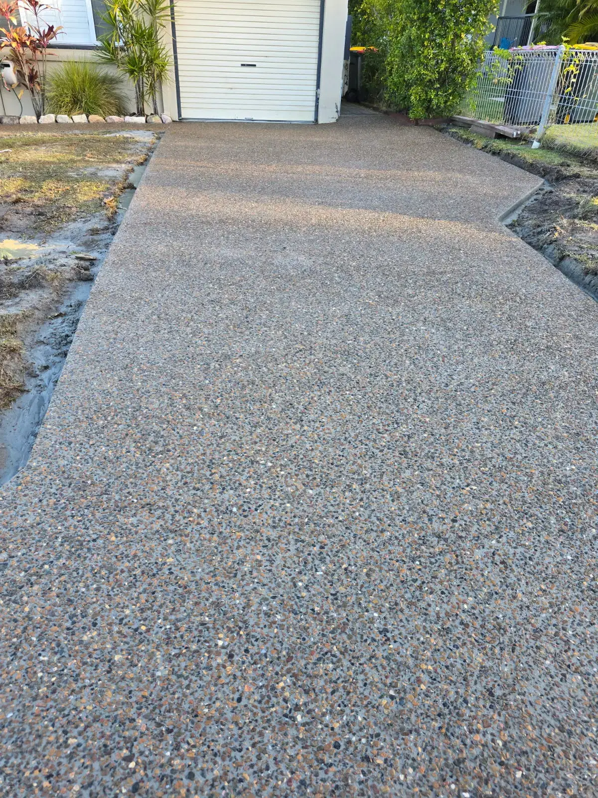 Exposed aggregate driveway leading to a residential garage in Brisbane