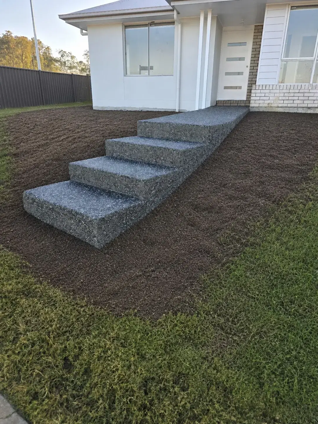Exposed aggregate front entry steps leading to a residential home