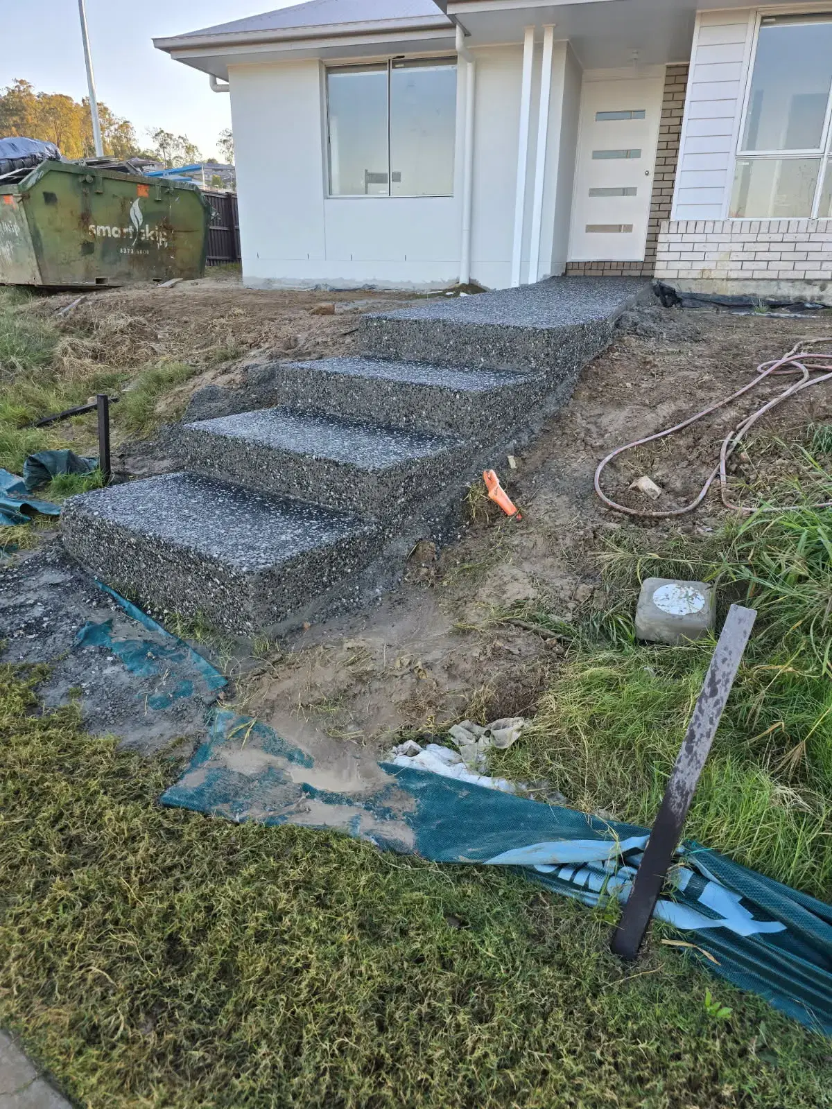 Exposed aggregate front entry steps leading to a residential home