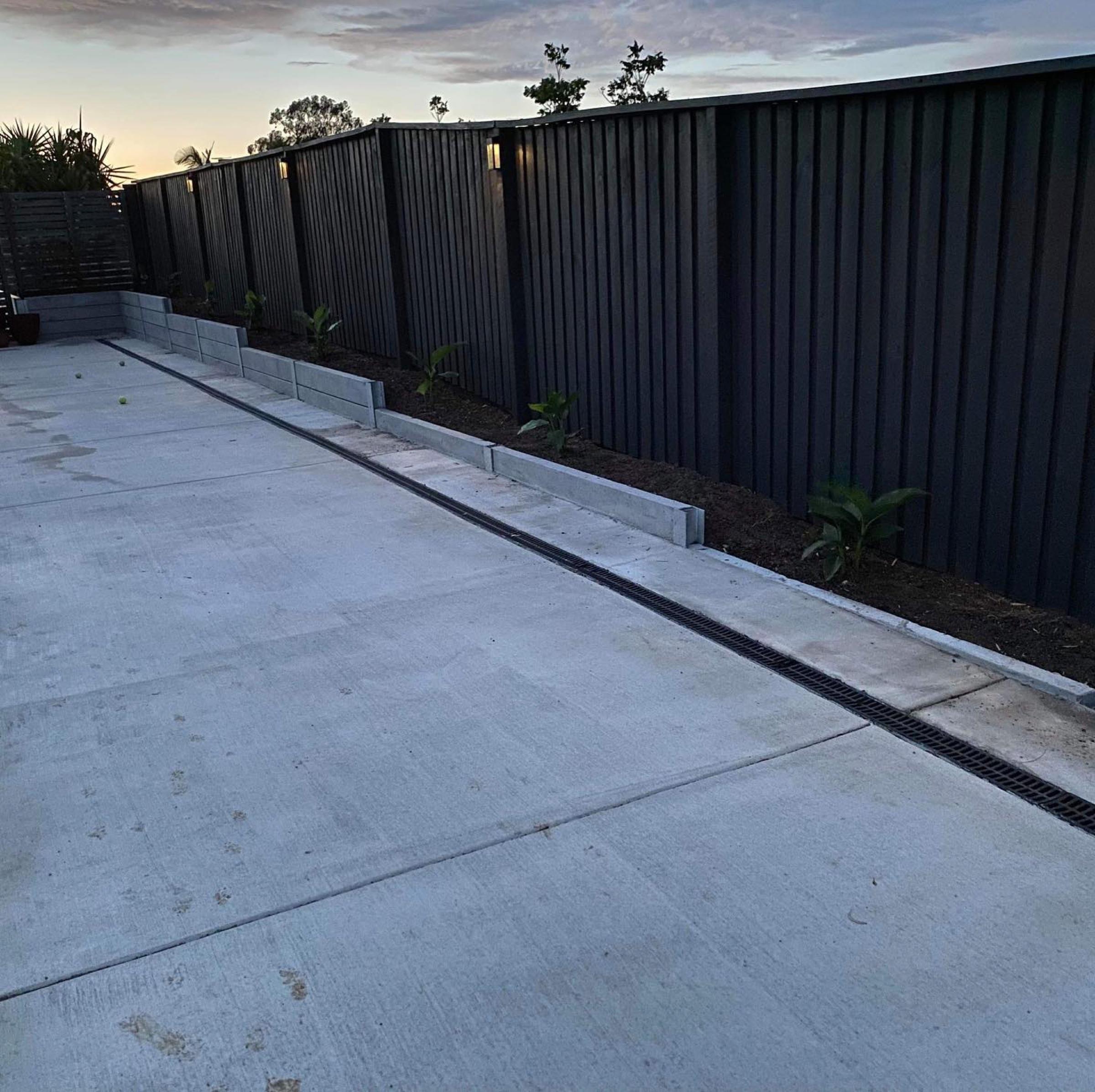 Wide plain concrete side access with channel drainage